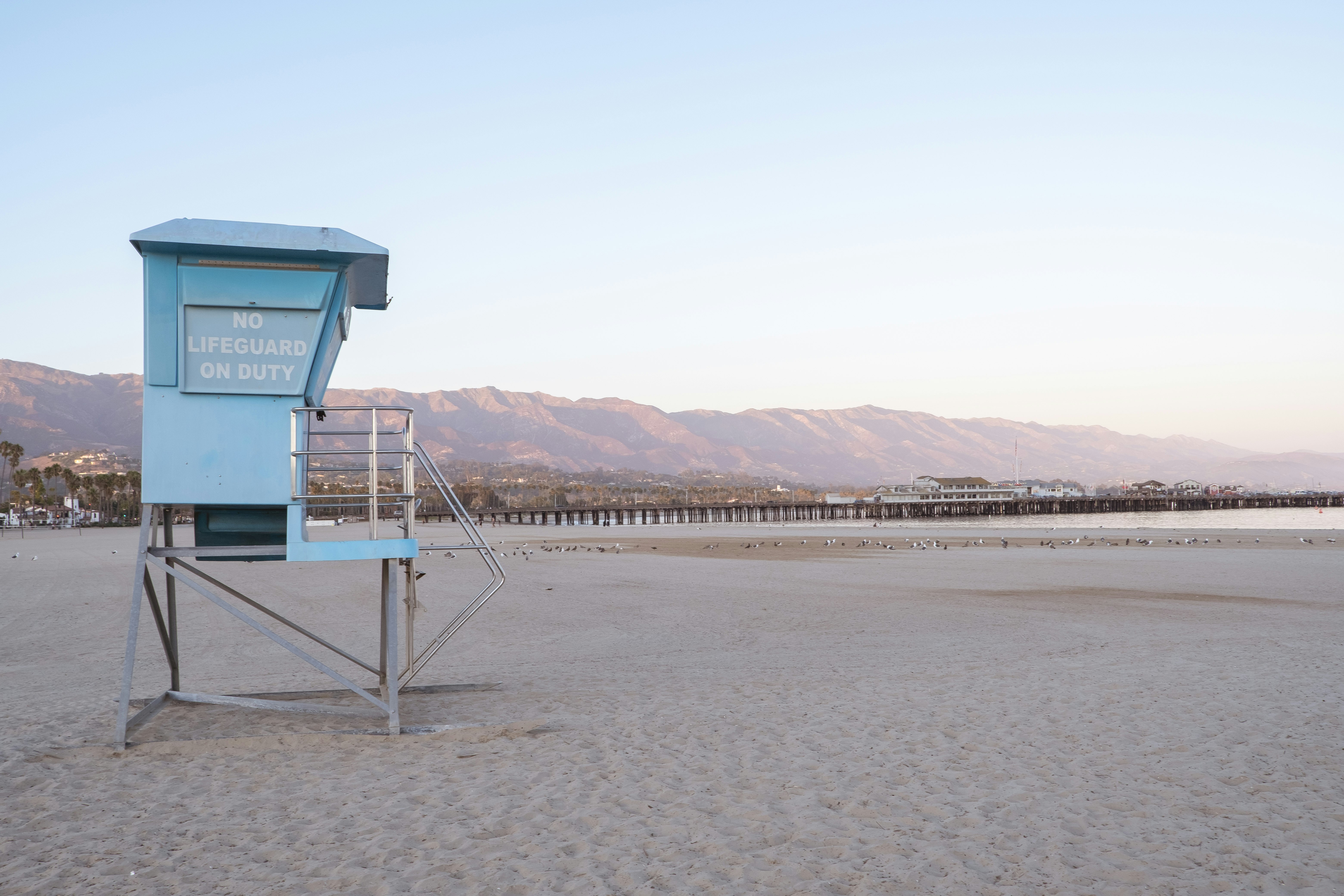 blue and white wooden lifeguard house on beach shore during daytime